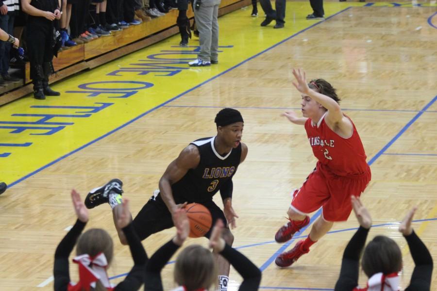 Jaquan Phipps '15 drives on a Hinsdale Central defender. 