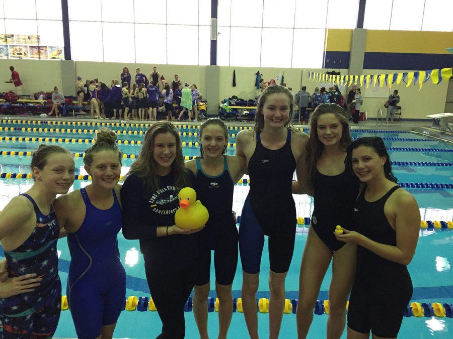 Wimmer stands center holding a rubber duck amongst fellow varsity teammates 