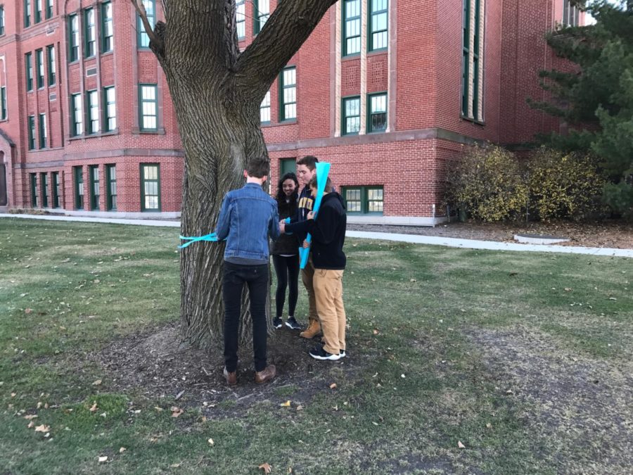 Durkins friends (Mac Weber 18, Michael Cooley 18, Nick Burriesci 18 and Cassidy McNichols 18) help tie ribbons.