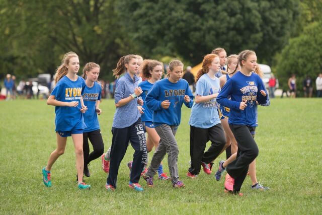 Varsity girls warming up prior to a race in Peoria (Photo courtesy  of Maddie Ohm 21).