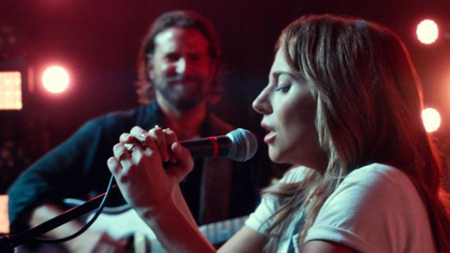 Lady Gagas character, Ally, takes the mike onstage as Bradley Cooper looks on (Warner Bros. Pictures).