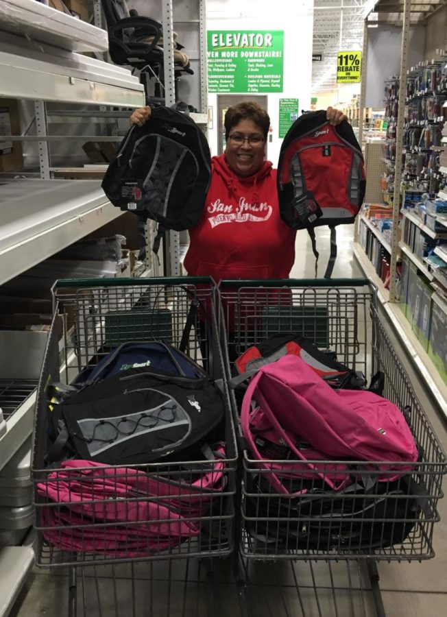 Mary Ann Rivera holding the backpacks that were donated to support individuals in Puerto Rico.