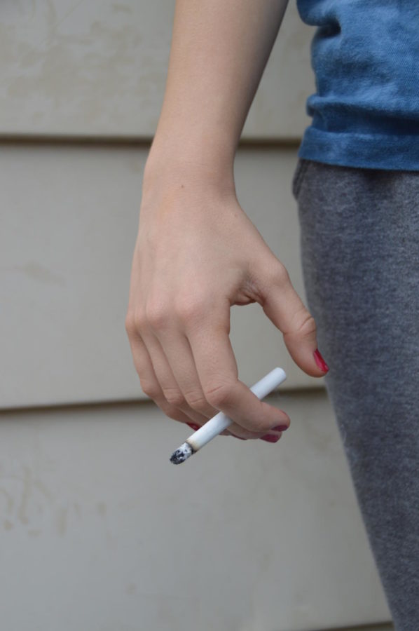 A woman holds a cigarette (LION).