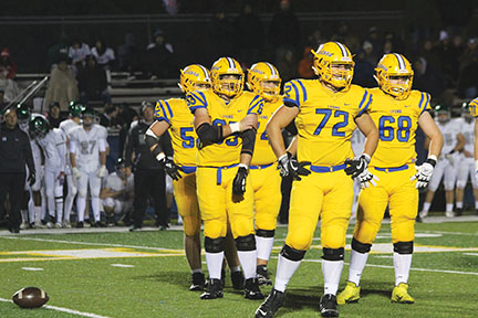 Offensive line watches coaches play run down during Glenbard West game on Bennett field on Oct. 4 (Sorice/LION).