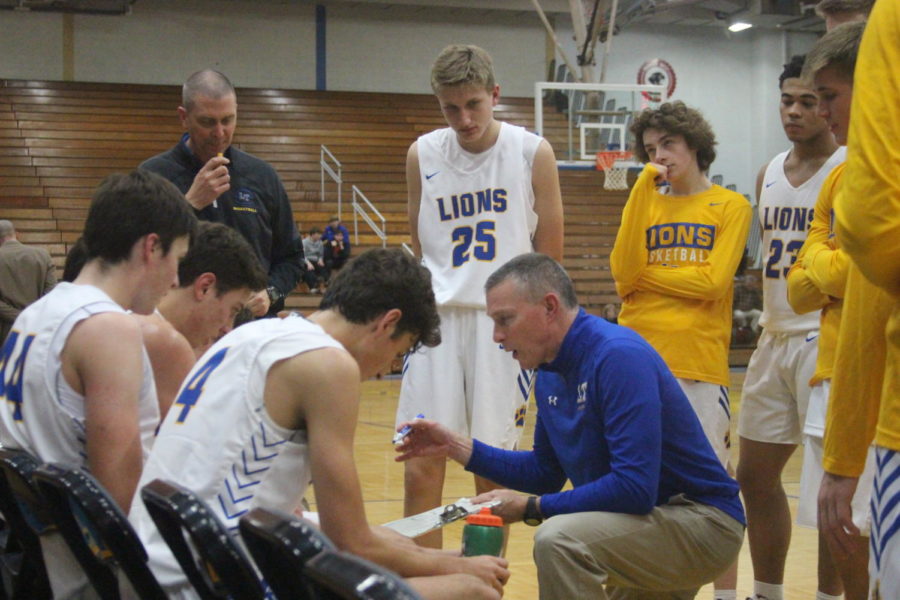 Coach Tom Sloan draws up plays in timeout during a game against Maine South on Nov. 27 in the NC field house (Layden/LION).