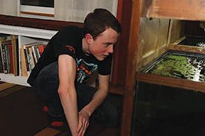 August Duwell 20 observes species of fish in his fish farm (photo courtesy of Ellie Pendleton). 