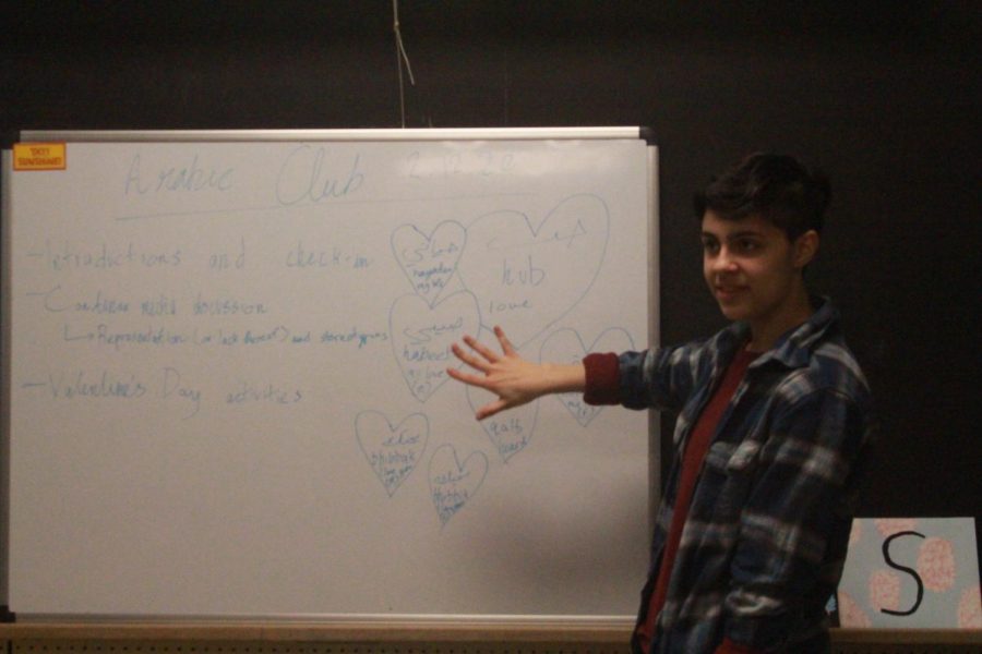 Ari Jameel 22 discusses and displays Arabic symbols at club meeting (Joyner/LION). 