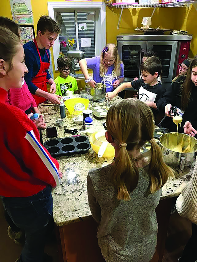 Genaro Giovingo-Mino patiently  teaches his  young students to bake cupcakes over the  summer of 2019 in his home kitchen (photo courtesy of Giovingo-Mino).