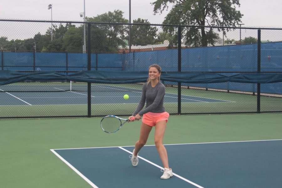 Junior varsity tennis player Charlotte McNealy’ 22 smiling whilst swinging her racket at her practice. (Robert Sullivan/LION)