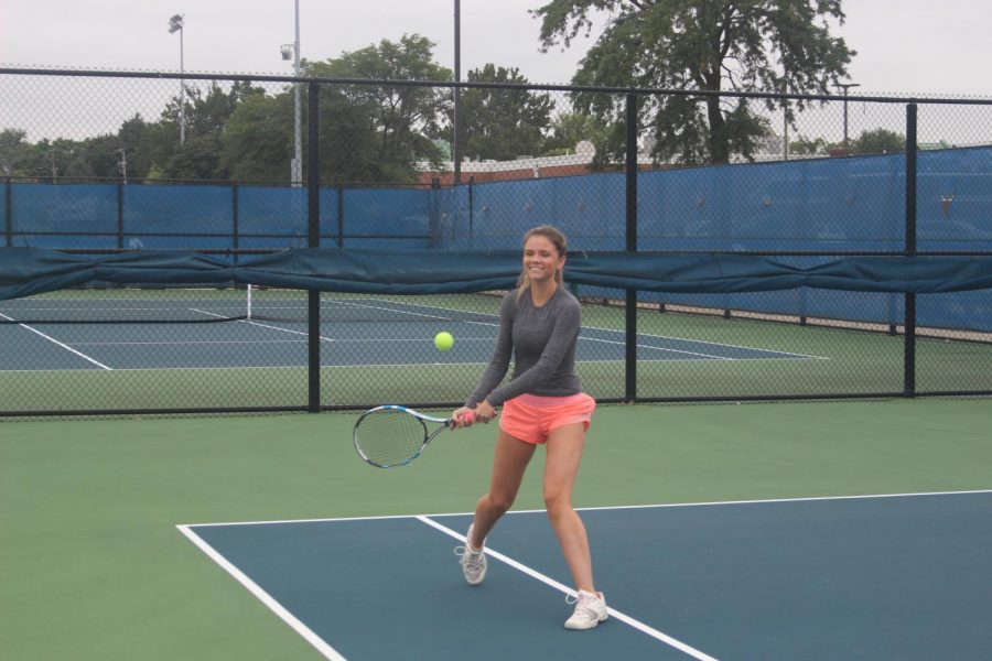 Junior+varsity+tennis+player+Charlotte+McNealy%E2%80%99+22+smiling+whilst+swinging+her+racket+at+her+practice.+%28Robert+Sullivan%2FLION%29