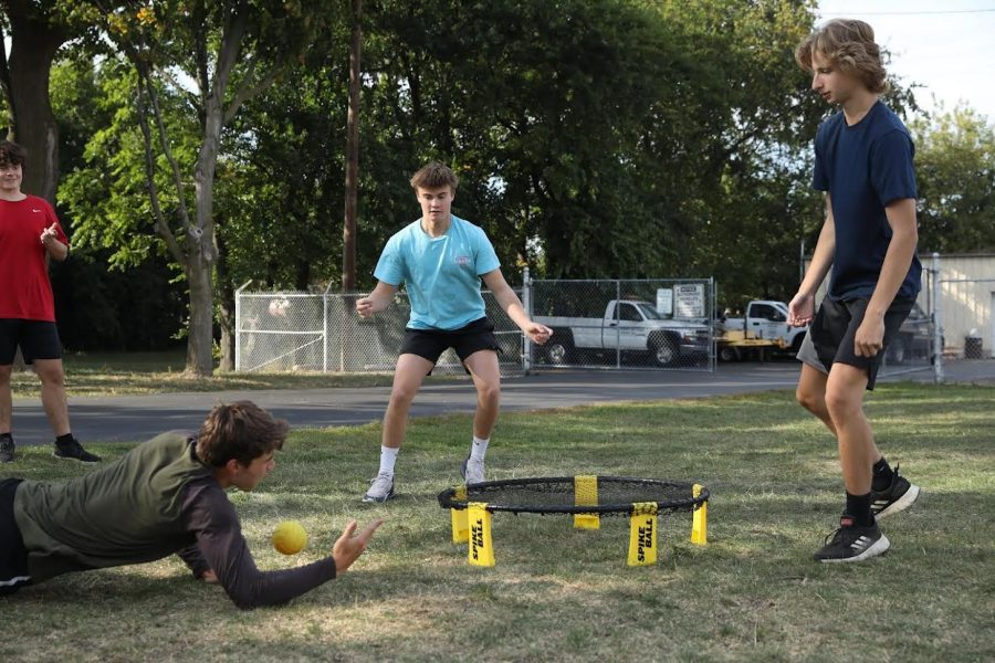 Michael Patera '23, on the right, Ryan Johnson '23, in the middle, and Chase O'Brien '23, diving, play Spikeball earlier this semester (photo courtesy of Grace Geraghty).