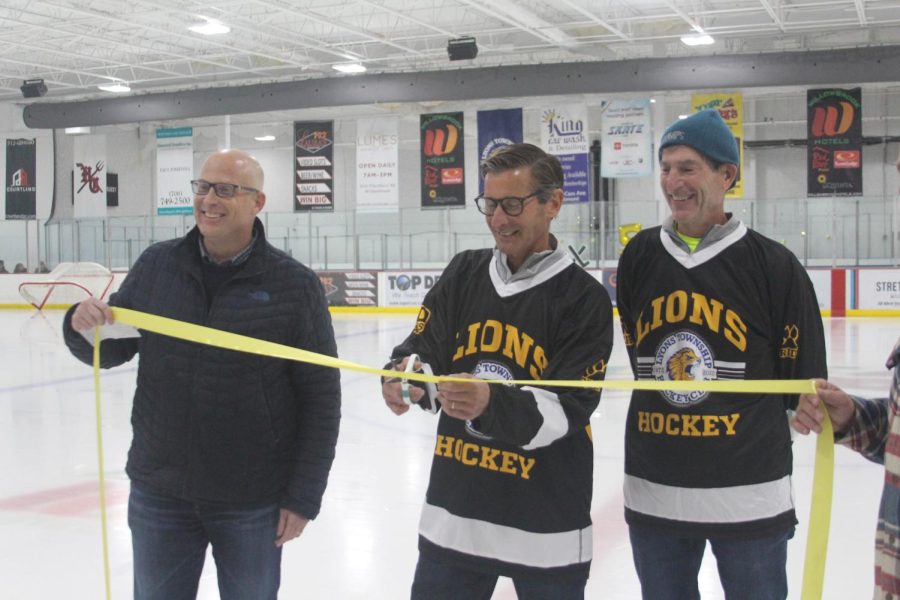 Brent Slezak, left, cuts ribbon as Jim Green, right, celebrates new LT hockey locker room (Wirtz/LION).