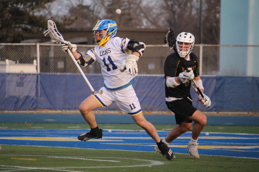 Sam Kidder 22 works to gather loose ball during home game against Waubonsie Valley HS on March 14 (Wolf/LION).