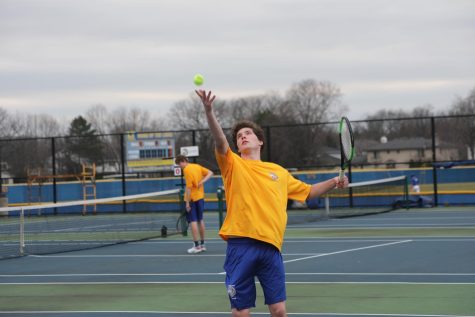 Will Carroll ‘22 serves up a tennis ball at match against York High School on SC courts April 12 (Burke/LION). 