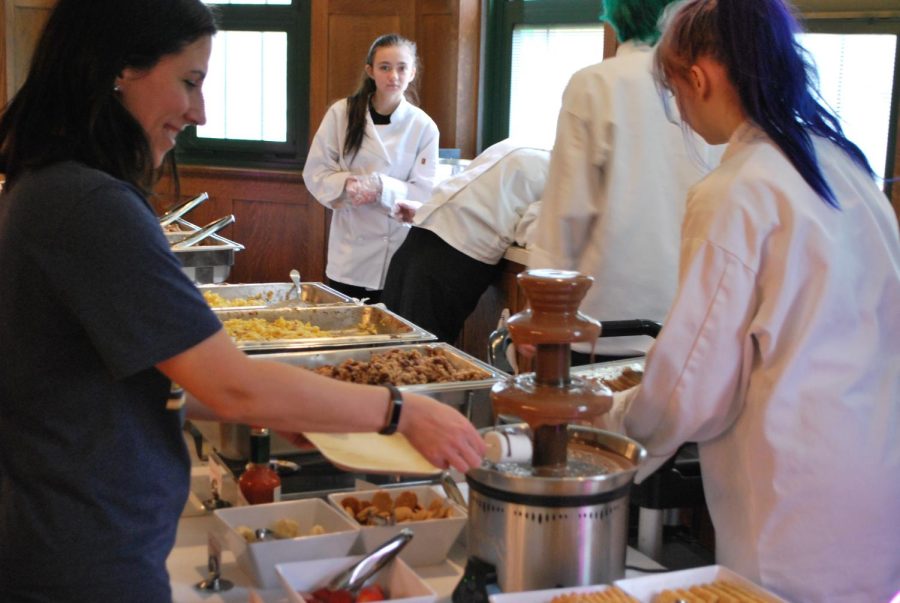 Spanish teacher Ellen Acuna dips dessert into chocolate fountain on May 5 (Lestina/LION).