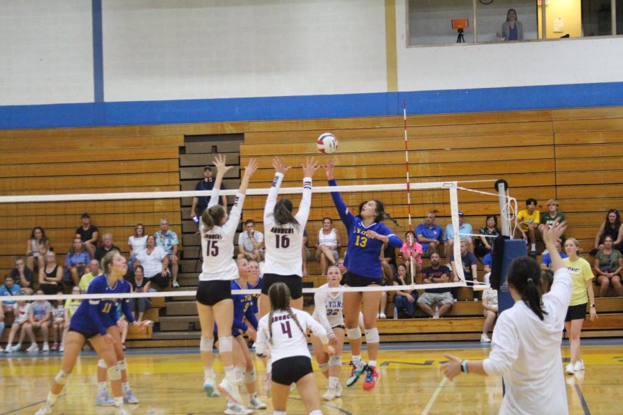 Kamryn Lee-Caracci 23 taps the ball wile defenders from Montini Catholic High School jump to block her (Ross/LION).