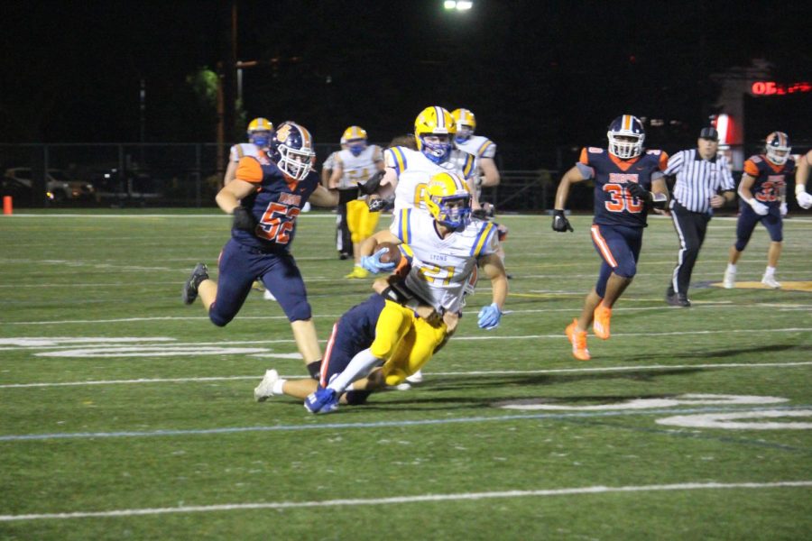 Running back Jack Cheney 24 pushes through a crowd of Buffalo Grove players (Barbera/LION).