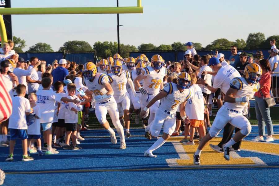 Graham Smith 23 #28 runs onto Bennett Field with teammates before winning whiteout game 10-7 against Hinsdale Central on Sept. 9 (Klos/LION).