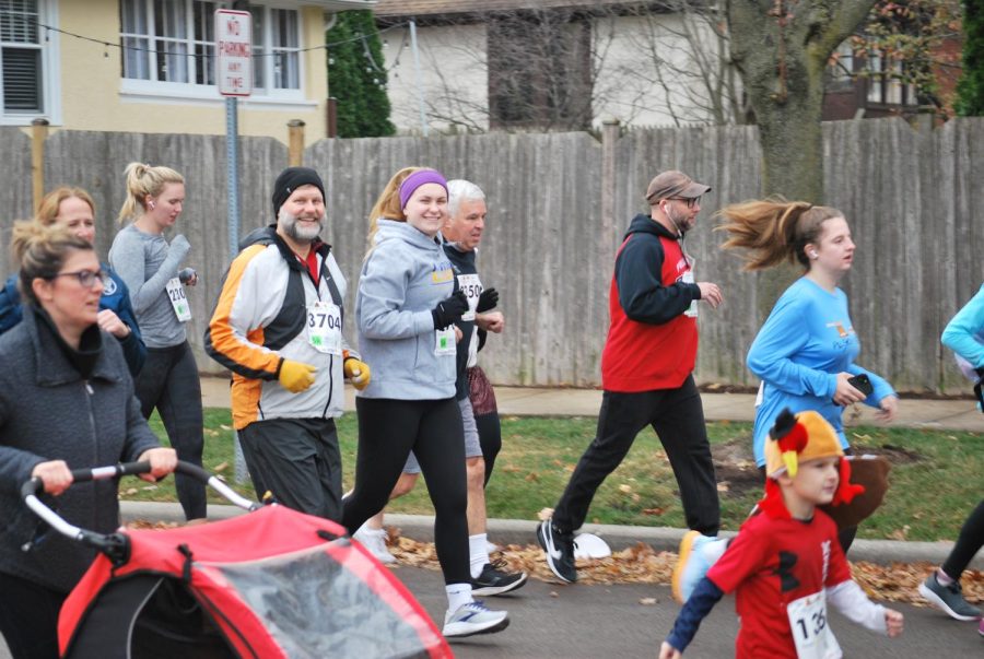 Lydia Busker ‘24 running alongside her dad shortly after crossing the starting line at Pilgrim Pie Run in La Grange on Nov. 24 (Davis/LION).