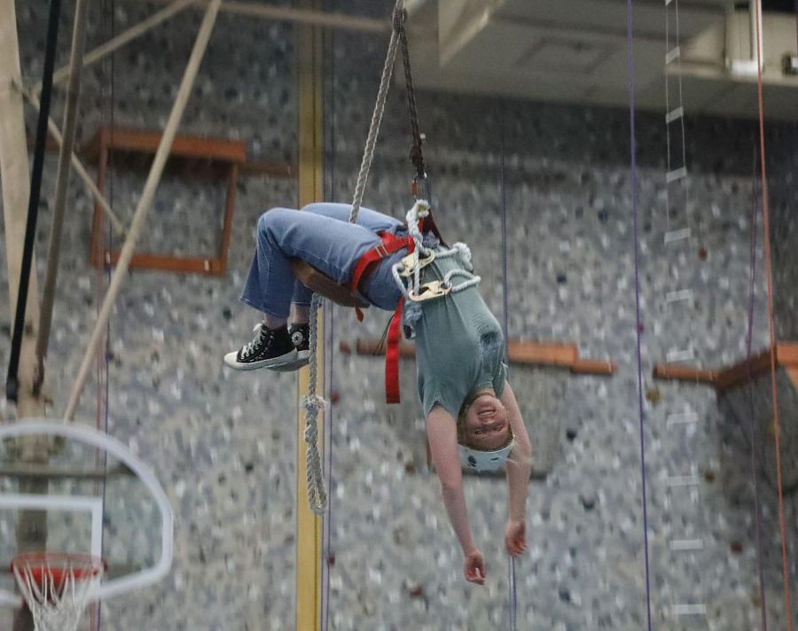 Taylor Dudek ‘23 soars across the NC Fieldhouse, hanging upside down on the giant swing during Rock Climbing Club (Pohl/LION). 