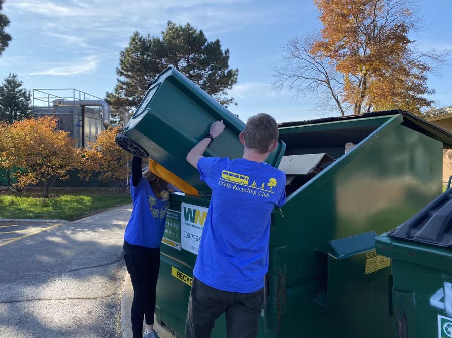 Club members Ben Hornickle 25 and Bridget Shoup 25 dump recycling into recycle-safe dumpster outside of SC (photo courtesy of Hornickle).