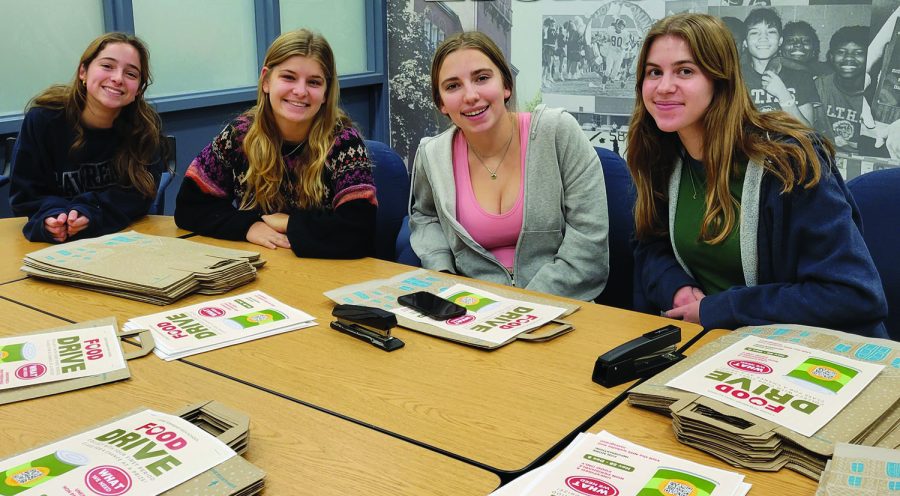 NHS members (from left) Allison Bloem, Gabrielle Pawlikowski, Grace Higgins, and Emily McKenna prepare classroom collection bags for the food drive (photo courtesy of Britt Ligmanowski).

