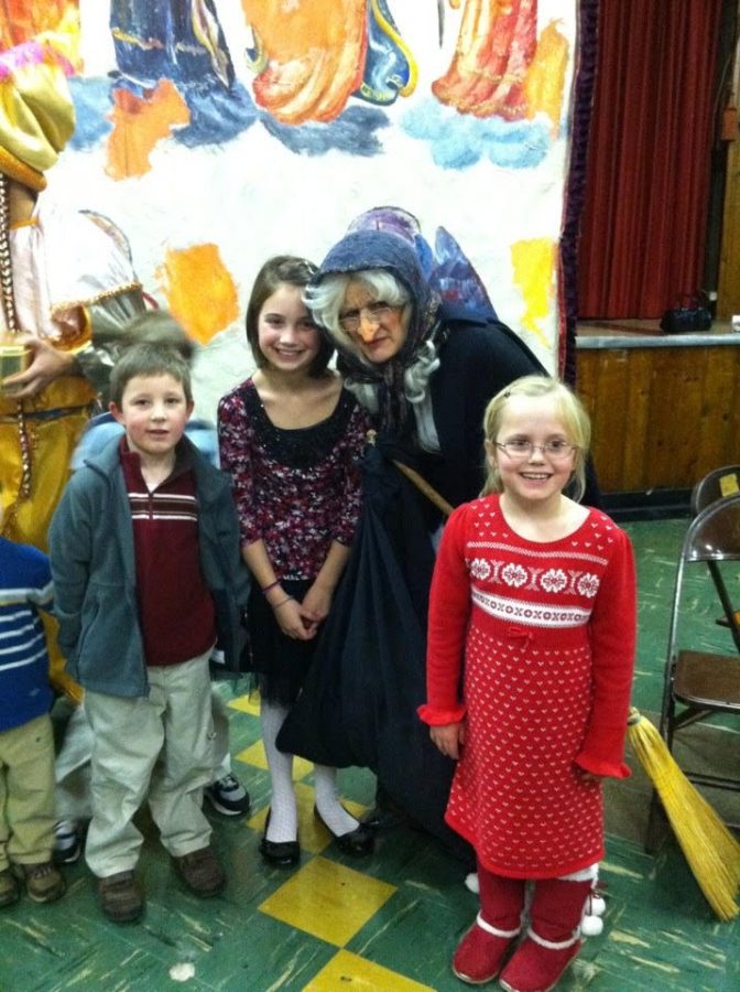 Matt Klos ‘24, Caroline Klos ‘20, and Juliana Moran pose for a photo with the La Befana impersonator after mass at Our Lady of Pompei in January of 2014 (photo courtesy of Klos).