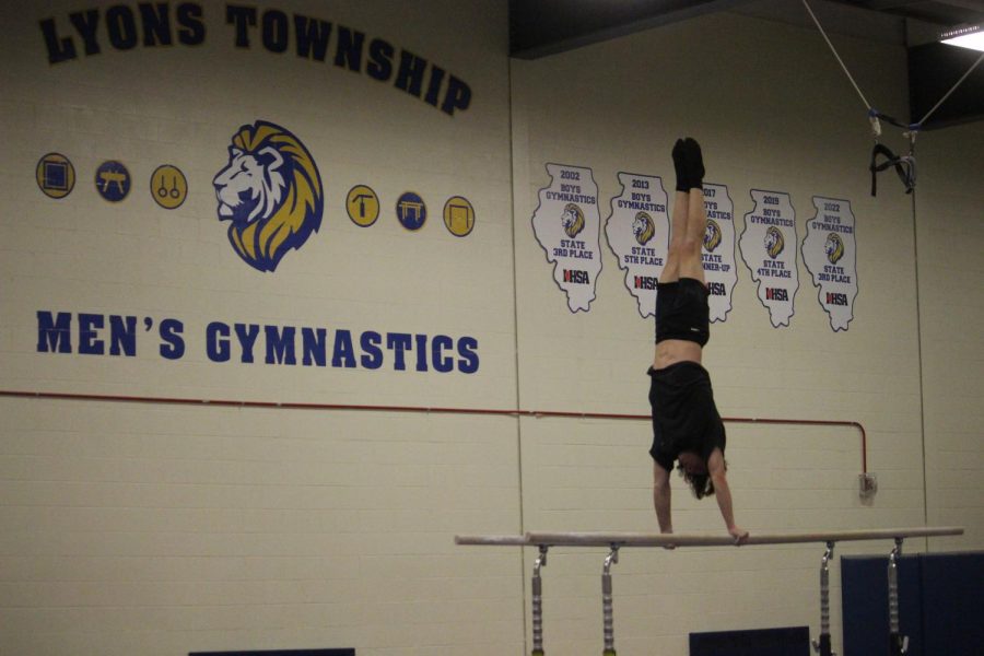 Will Taylor 24 practices a routine on the high bars during open house in gymnastics gym on Jan. 18 (Ross/LION)
