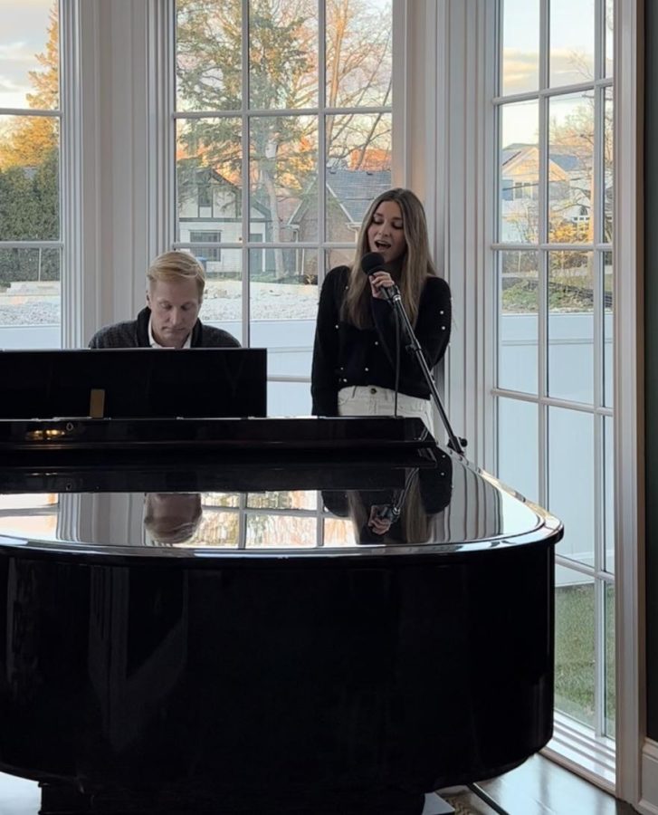 Sophia Zich ‘24 sings her original song ‘By Your Side’ alongside her father, David Zich, in their atrium (photo courtesy of Sophia). 