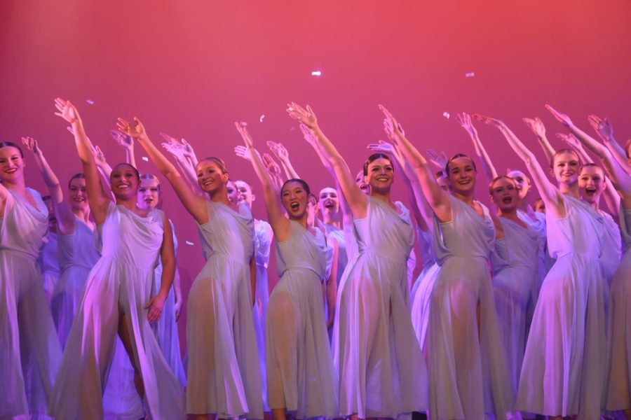 Eurythmic dancers face the audience waving a hand in the air.