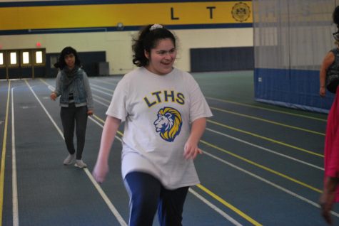 Iliana Garza ‘25 enthusiastically practices high knees warmup before running station (Ludden/LION) 