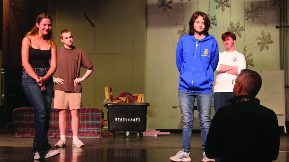 Director Michael Kuehl instructs cast members Thomas Norgle ‘25, Abigail Burns ‘26, Emmet Gripp ‘26, and Ellie Watkins ‘24 on an improv game in preparation for opening night (Kowalski/LION). 