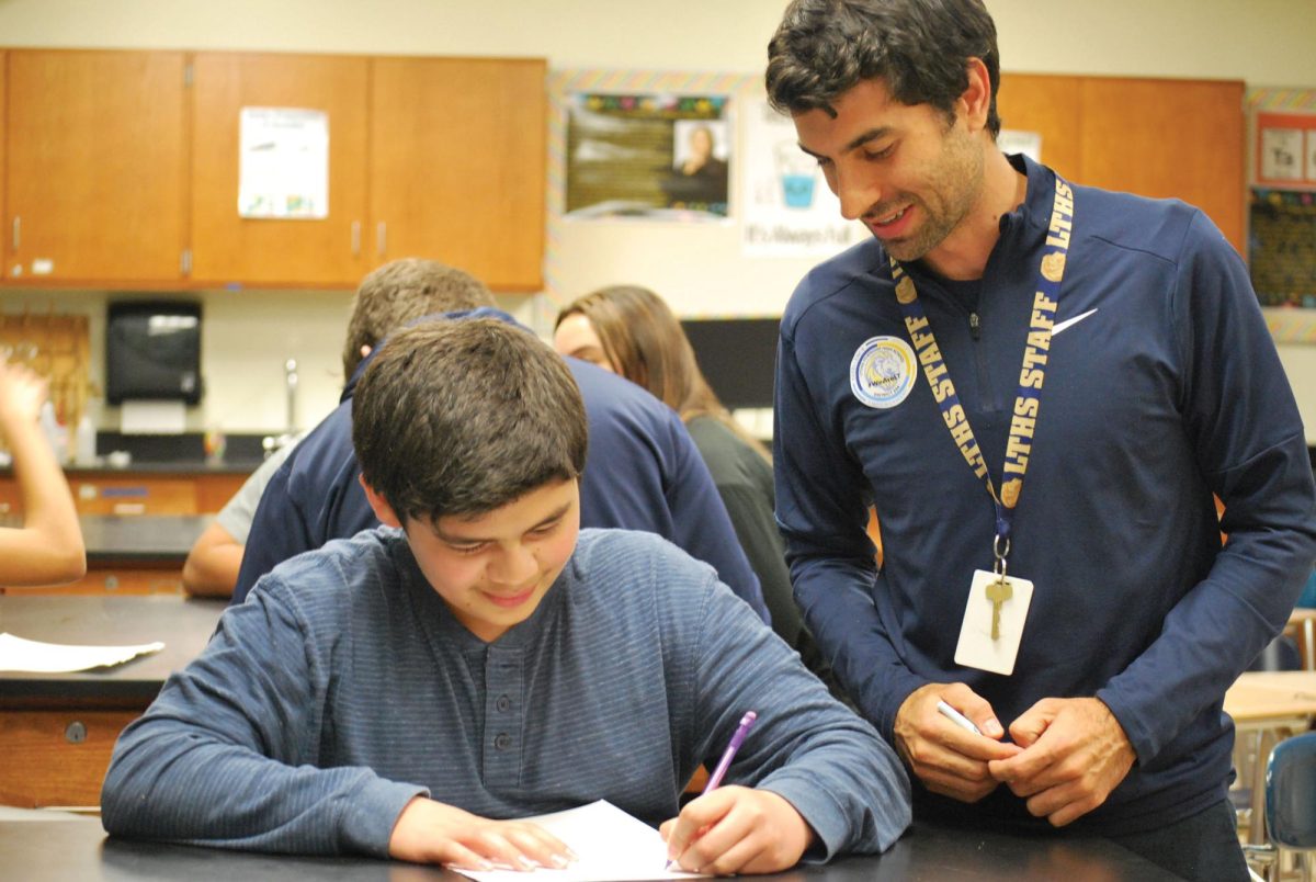 Jose Oleaga works alongside student in Spanish Club at SC (Arteaga/LION). 