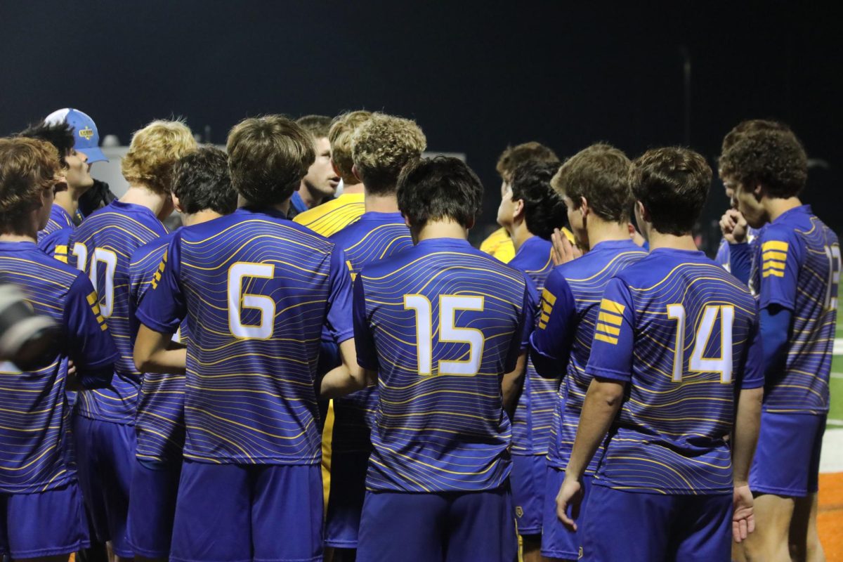 Team huddles around coach as he gives a pep talk before the start of the game (James/LION).
