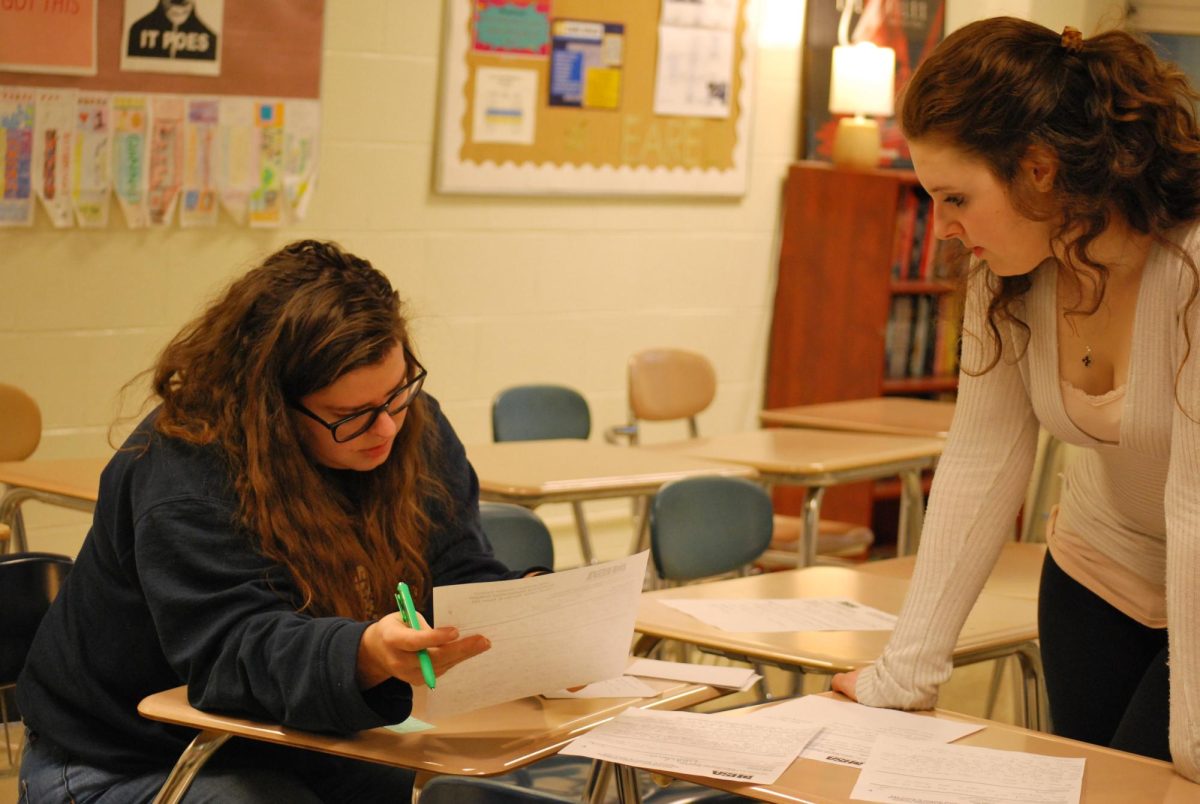 Speech coach Julie Ozols analyzes judging sheets from regionals with speech member London Shannon-Muscolino 25 (Arteaga/LION). 