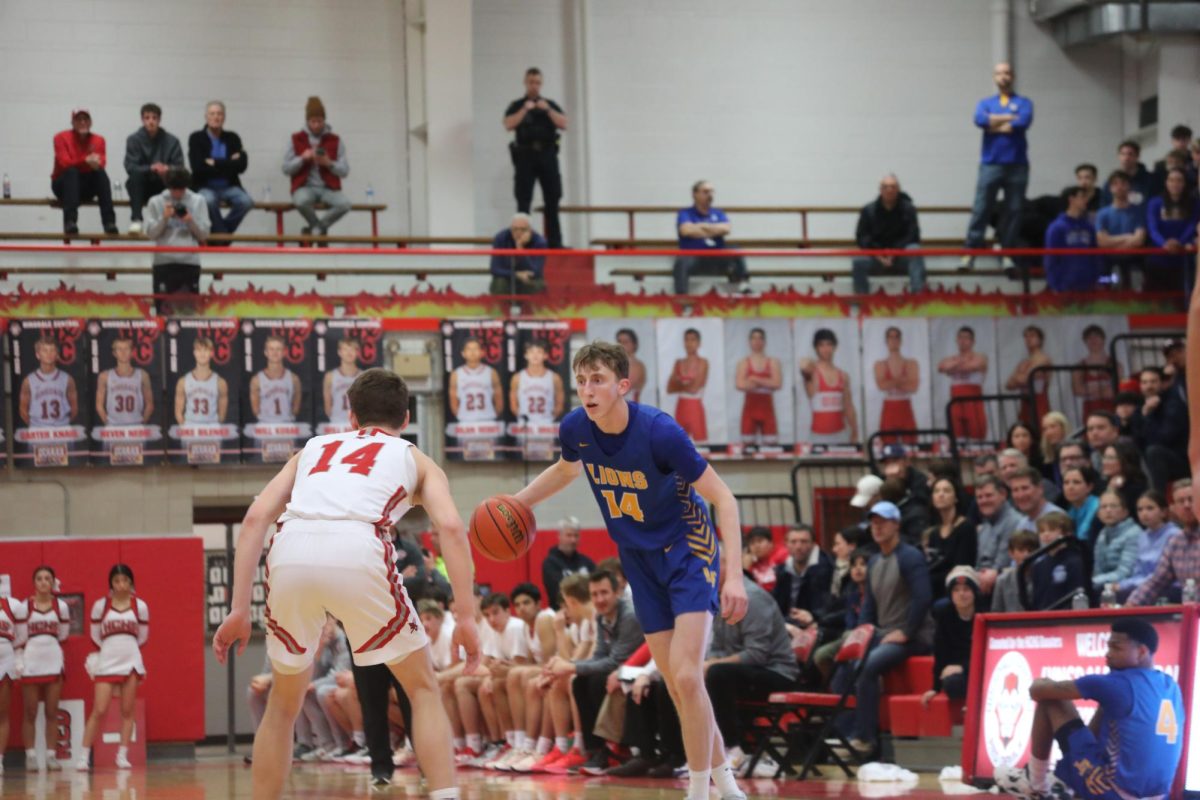 Liam Taylor ‘24 scans the court for an open teammate against Hinsdale Central on Jan. 19 (Ludden/LION). 