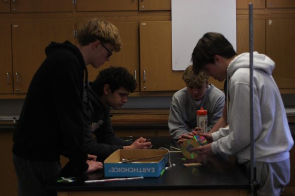 Dominic Kent ‘25 and Brendan Lopez 25’ helping their peers build a mousetrap car in room 213 at North Campus on March 6.
