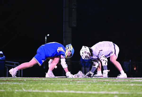 Connor O’Malley ‘24 faces off for possession of the ball against Wheaton Academy on March 14 (Klos/LION). 