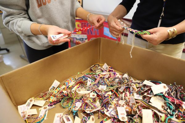 Lisa Plichta and Ava Strickler 24 take time during 4B Study Hall in NC Room 321 to browse the selection of colorful handmade pulsera bracelets in the box (Arteaga/LION). 