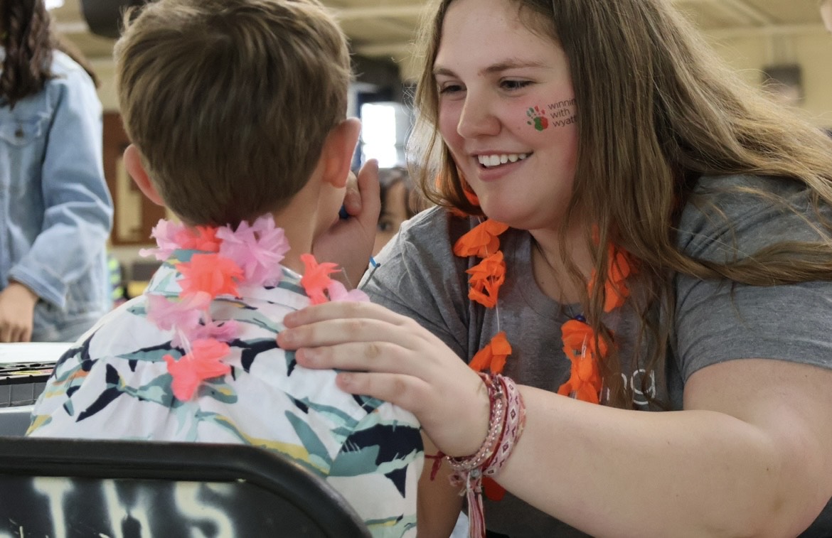 Volunteer Erin Busby '26 paints on attendees face on April 26 (photo courtesy of Brooke Stack).
