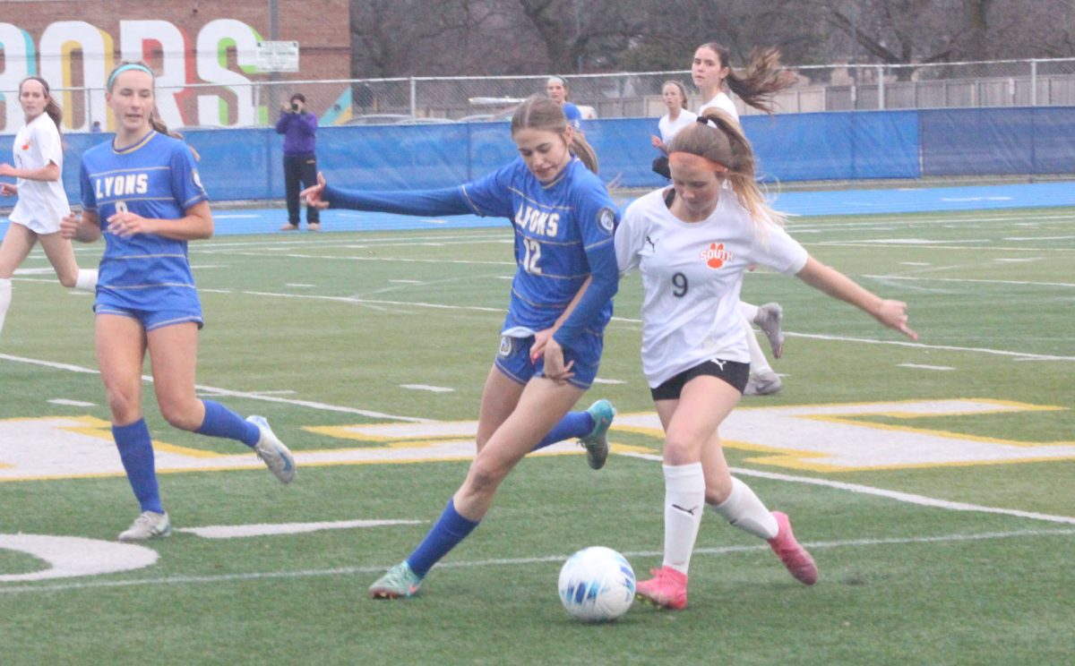 Emma Thimm '28 fights for the ball versus Wheaton Warrenville player on Bennett Field on March 27