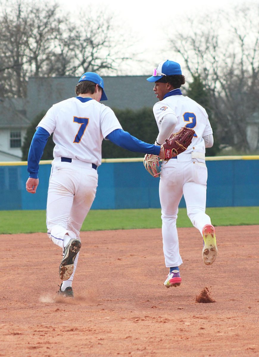 Luke Nicholaus ‘25 supportively pats teammate Blake Ragsdale ‘26 while returning to positions in a game against Brother Rice (Simmons/ LION).