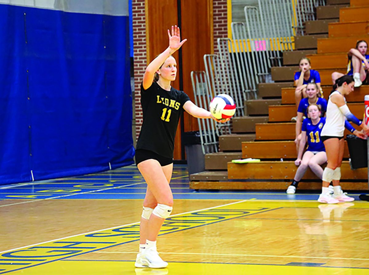 Kate Potter '26 stares down court, preparing to jump serve during the Sept. 9 game against Downers Grove North (Brooks/LION). 