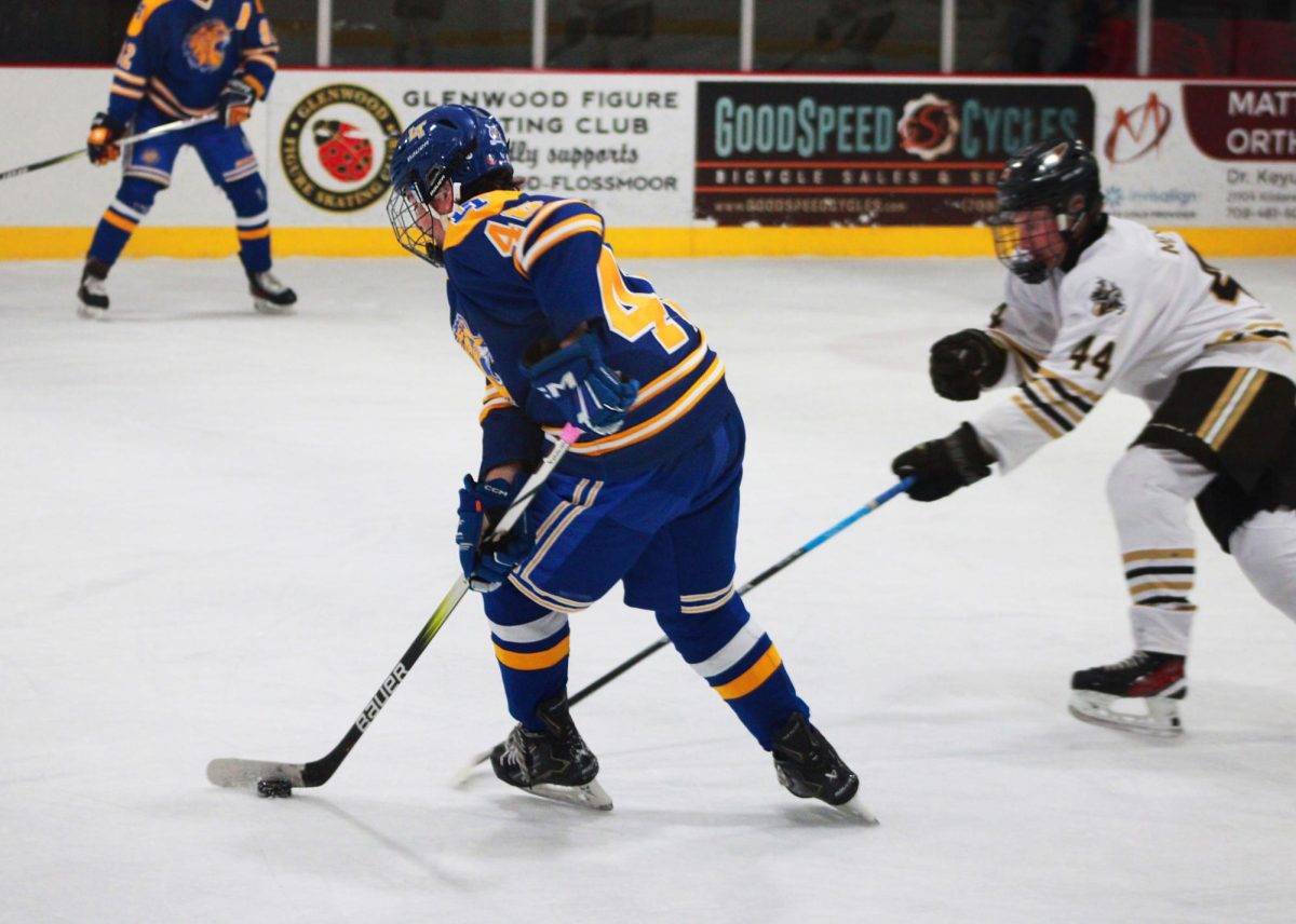 Bodin Montgomery ‘27 swiftly skates with the puck past Lincoln Way advisory on Oct. 12 during an away game (Simmons/ LION).