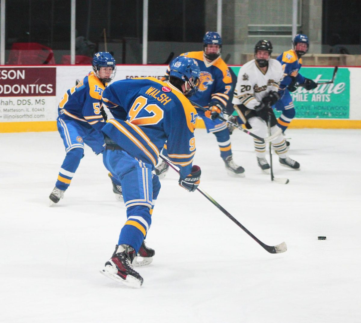 Charlie Walsh ‘26 rushes to steal the puck from Lincoln-Way opponents (Simmons/LION).