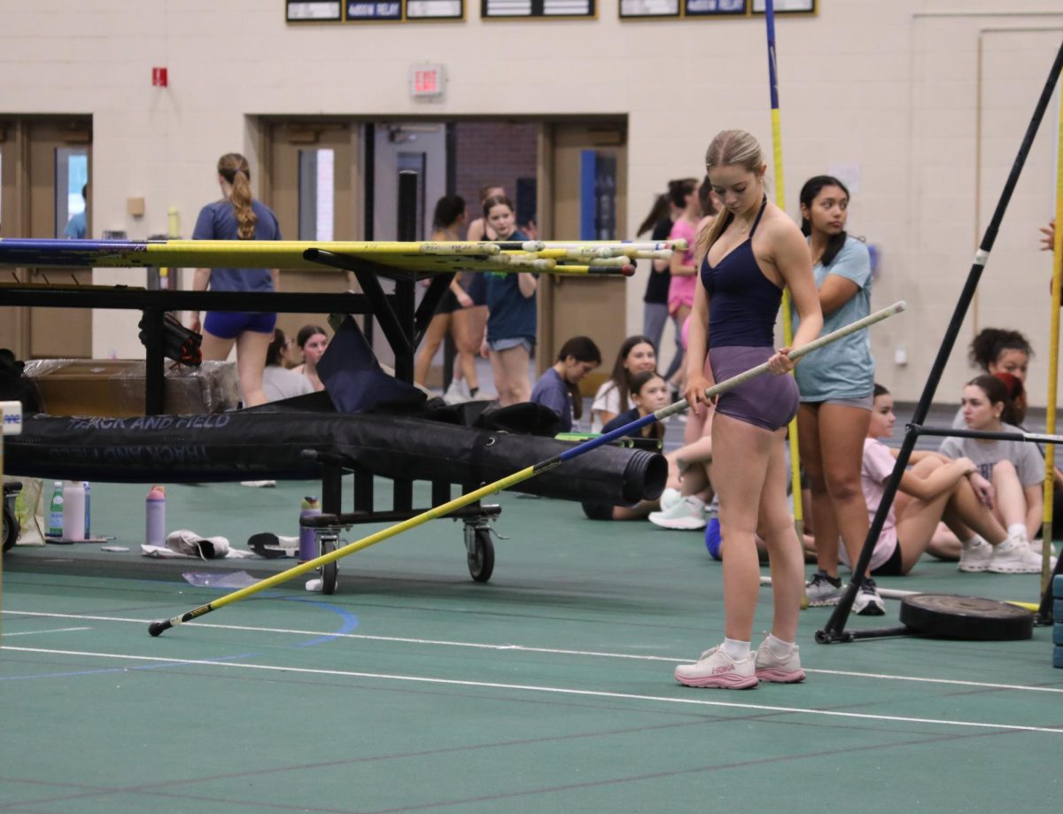Maeve Cochran ‘27 checks her grip before attempting a pole vault during practice on Jan. 30 at SC fieldhouse (Brooks/LION). 
